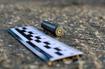 empty cartridge at the crime scene against the background of a forensic ruler