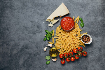 Typical Italian food Pasta spaghetti,  parmesan cheese, olive oil, spices, basil, tomato sauce and fresh tomatoes. top view