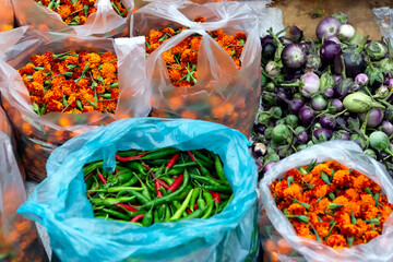 Aubergines,flowers and chilies for sale in the street market in Luang Prabang, Laos