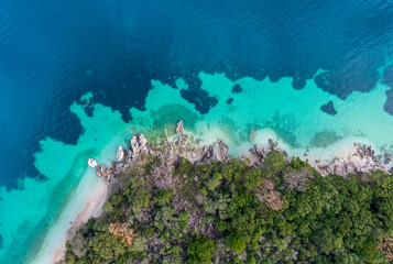 Top-down aerial view of a clean white sandy beach on the shores of a beautiful turquoise sea in corfu Greece