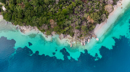 Top-down aerial view of a clean white sandy beach on the shores of a beautiful turquoise sea in...