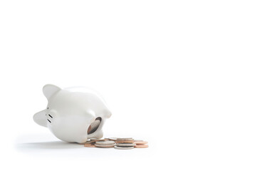 Closeup of a piggy bank and coins on white background with copy space