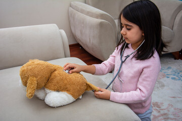 Little girl examining her teddy dog