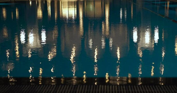 Swimming pool by night hotel. A view of swimming pool by the bright summer hotel in the night.