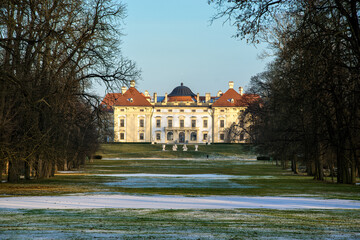 Fototapeta na wymiar Slavkov Castle in the Czech Republic illuminated by the sun in winter. Snow lies in the park and garden in front of the castle.