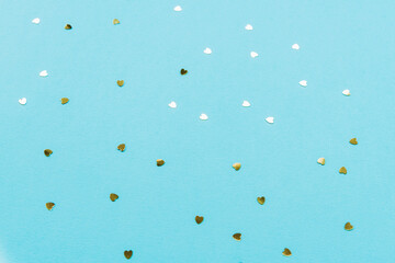 Golden hearts confetti on teal blue background. Valentines day concept. Festive background