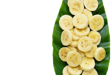 Banana slices on green leaves on white background.