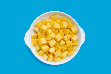 Tropical fruit, Mango cube slices in white bowl on blue background.