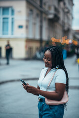 African american woman using smartphone while out in city