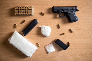 Top view of drugs paraphernalia, gun, bullets and cocain narcotics packaging ready for street distribution.
