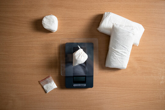 Drugs paraphernalia and cocain narcotics packed and measured on scale ready for street distribution.