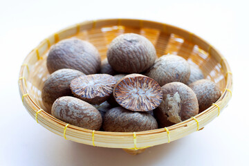 Betel nut in bamboo basket on white background.