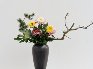 Beautiful flower composition with autumn Chrysanthemum flowers . Autumn bouquet in vintage vase on a white wall background.