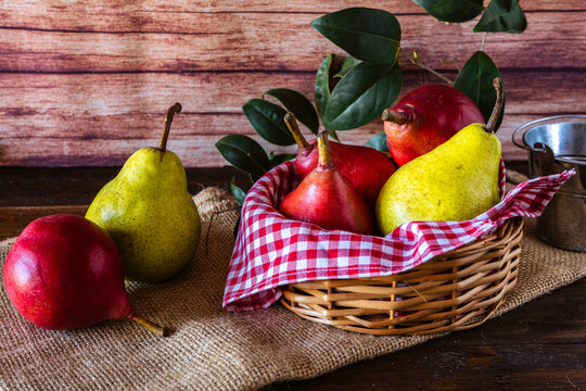 Red battler pears or red pear and packham or green pears in a basket on a table. Organic and natural products.