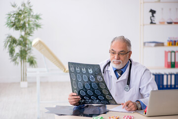 Old male doctor radiologist working in the clinic