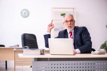 Old businessman employee sitting in the office