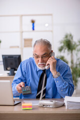 Old male bookkeeper working in the office