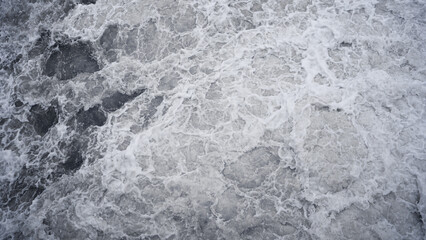 Top view of marine foam made of breaking on the beach waves 