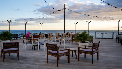 Lounge open air cafe with big terrace with panoramic sea view with modern style wooden chairs