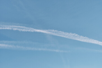 Blue sky with airplane contrails as abstract background