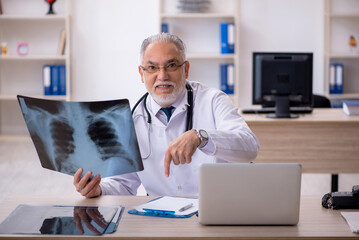 Old male doctor radiologist working in the clinic