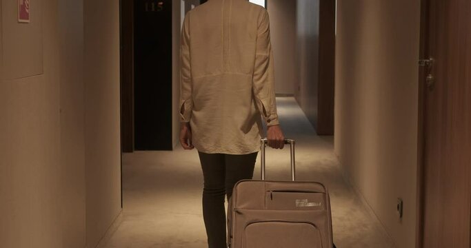 Woman in hotel hallway. A woman walk along the hotel hallway with a tourist case.