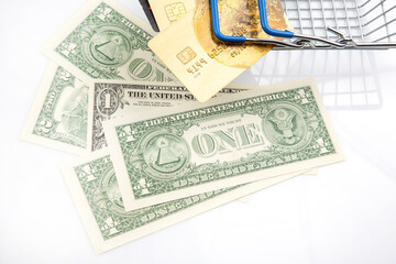 Dollars and credit cards in a shopping cart. Business investments and purchases. Sales market and...