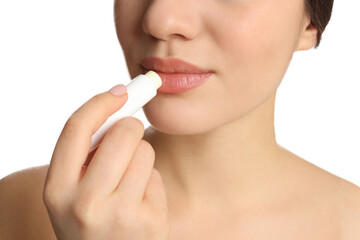 Young woman applying lip balm on white background, closeup - obrazy, fototapety, plakaty