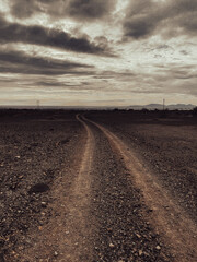 dark empty desert mountain trail adventure evening dusk horizon silhouette sepia dirt road moody...