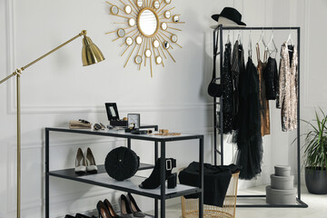 Stylish dressing room interior with trendy clothes and luxury accessories