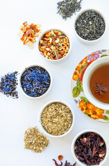 Dried herbal tea. Variety of dry tea in utensils, on white background