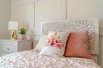 Single bed and bedside cabinet against the white bedroom wall with paneling