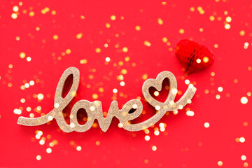 Fototapeta na wymiar Red paper heart and golden word LOVE on a bright red background. Valentines Day concept