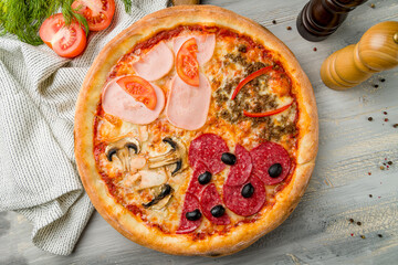 Pizza four seasons on grey wooden table top view