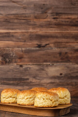 group of scones on wood plate with jam on table