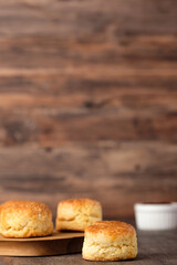 group of scones on wood plate with jam on table