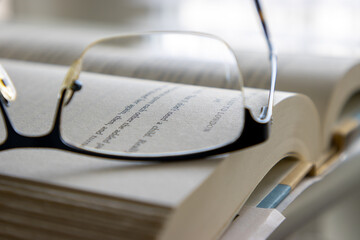 Close up reading glasses and book