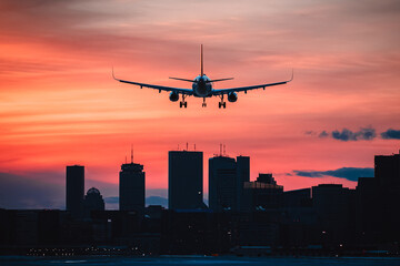 Fototapeta na wymiar Plane Landing in Boston at sunset