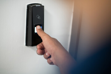 Man pressing fingerprint scanner on alarm system indoorsFinger print scan for unlock door security...