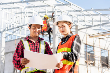 Two architect and client discussing help create plan with blueprint home building at construction site. Asian engineer foreman worker man and woman meeting talking on drawing paper project