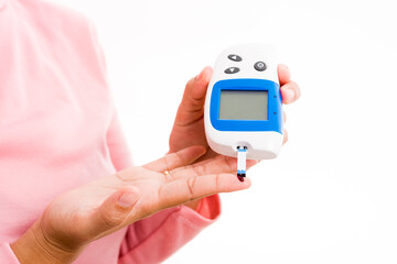 Closeup hands woman measur glucose test level check with blood on finger by glucometer she monitor and control high blood sugar diabetes and glycemic health care concept isolated on white background