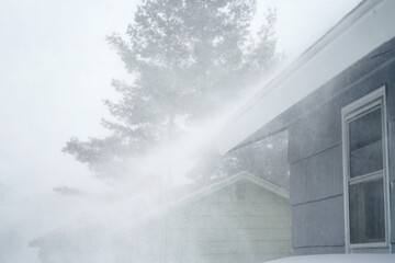 strong wind blowing snow off the roof in blizzard - obrazy, fototapety, plakaty