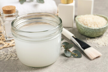 Homemade natural rice water and cosmetic products on light grey table