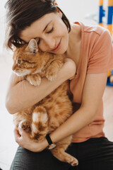 Caucasian woman hugging with love her red maine coon kitten. Beautiful girl. Beautiful female person. Adorable pet.