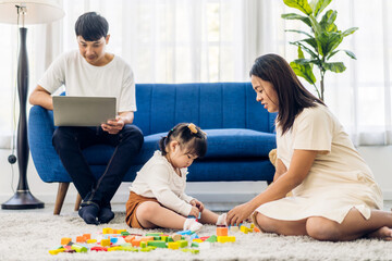 Naklejka premium Portrait of enjoy happy love asian family father and mother with little asian girl smiling activity learn and skill brain training play with toy build wooden blocks board education game at home