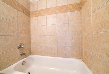 Alcove bathtub close up with brown ceramic tiles surround