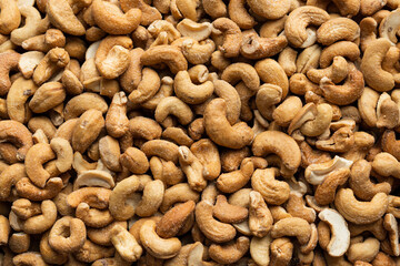 Background of organic salted cashew nuts. Natural pure salted cashew nuts. Scattered salted cashew nuts grains. Roasted salted cashew for snack. Healthy eating with food from nature