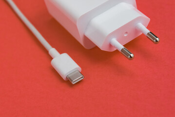 Charger and USB cable type C over pink background