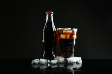 Bottle and glass of refreshing soda water on black background