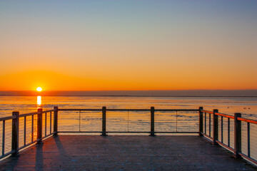 Fototapeta na wymiar Sunrise over the water by the dock